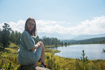 Image showing Woman resting at mountain lake in summer