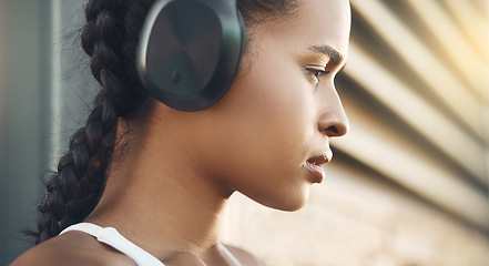 Image showing Closeup, outdoor and woman with headphones, fitness and exercise with focus, workout goal and wellness. Female person, model and athlete with headset, city and streaming music with training and relax