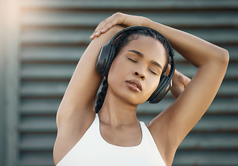 Image showing Stretching, city and woman with headphones, fitness or exercise with motivational podcast, relax or stress relief. Female person, athlete and girl with headset, streaming music or radio with wellness