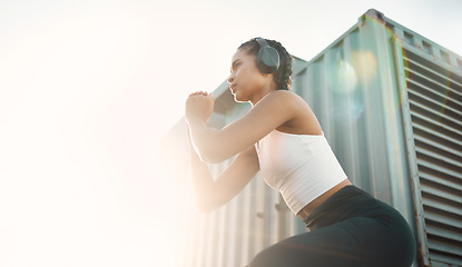 Image showing Fitness, woman with headphones and training with lens flare for motivation. Exercise or workout, health wellness or cardio and young female athlete squat in sportswear for healthy lifestyle