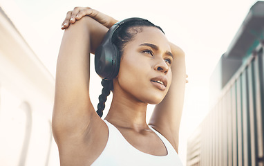 Image showing Stretching, city and woman with headphones, training and stress relief with exercise, audio and radio. Female person, athlete or girl with headset, streaming music and wellness with fitness and relax