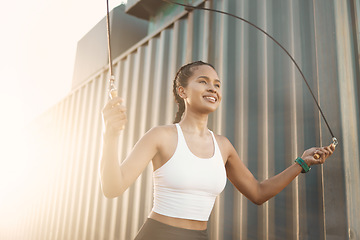 Image showing City, jumping rope or happy woman in fitness training, workout or body exercise for cardio outdoors. Girl thinking, active or healthy female sports athlete skipping with smile for wellness in town