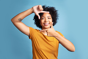 Image showing Portrait, frame and woman with a smile, focus and confident girl against a blue studio background. Face, female person or model with hand gesture, framing and shape with profile picture and happiness