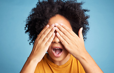 Image showing Shock, scared and woman closing her eyes in a studio for fear, horror or panic expression. Surprise, emotion and crazy female model with a cant look gesture or emoji isolated by a blue background.