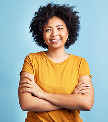 Image showing Happy, woman and portrait with arms crossed, confidence and natural beauty blue background in studio. Face, happiness and person with African hair, afro or student in college with pride