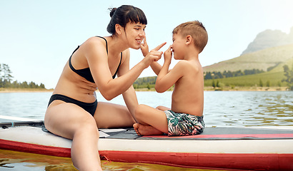 Image showing Lake, nature with mother and son on paddle board, relax outdoor with summer holiday and travel. Adventure, freedom and fun, family with woman and boy child in swimsuit, vacation and bonding together