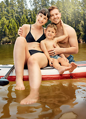 Image showing Lake, family on paddle board and relax outdoor, summer holiday and travel in portrait. Adventure, freedom and fun, man and woman with boy child in swimsuit, vacation and bonding together in nature