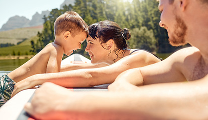 Image showing Nature, bonding and family swimming in a lake together while on vacation or adventure in the woods. Happy, love and mother embracing her boy child while having fun in pond on holiday or weekend trip.