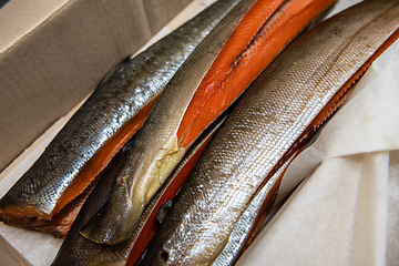 Image showing Smoked fish in craft paper box.
