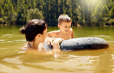 Image showing Travel, float and mother with her child in lake swimming while on a summer vacation or adventure. Happy, tubing and young mom bonding with boy kid in outdoor pond on tropical weekend trip or holiday.