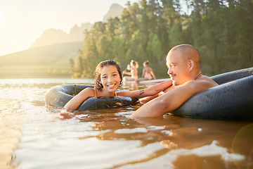 Image showing Portrait, tube or happy couple in lake to relax on holiday travel, vacation, or weekend together. Smile, float or woman swimming with freedom, joy or romantic man in river water, dam or calm nature