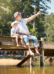 Image showing Grandfather, child and pointing while fishing at lake for fun hobby, adventure and teaching about nature. Boy kid, view and learning to fish with senior man at river, camping trip and happy vacation