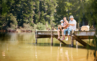 Image showing Father, grandfather and child fishing at lake together for fun bonding or peaceful time in nature outdoors. Dad, grandpa and kid enjoying life, catch or fish with rod by water pond or river in forest