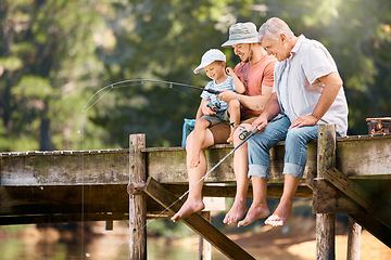 Image showing Dad, grandfather and teaching child fishing at lake together for fun bonding, lesson or activity in nature. Father, grandpa and kid learning to catch fish with rod by water pond or river in forest