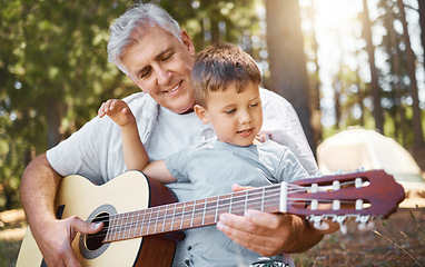 Image showing Senior man, boy and camping with guitar, music and teaching with freedom, smile or outdoor in summer. Grandfather, instrument and male child in forest, learning and retirement on vacation in nature