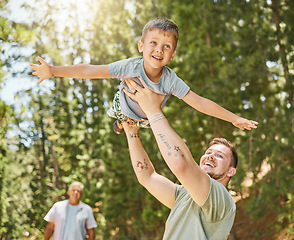 Image showing Hiking, love and a boy flying with his father outdoor in nature while camping in the forest or woods. Family, fun and a young child son playing with his happy dad or parent in the sunny wilderness