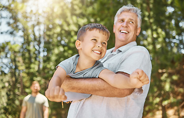 Image showing Hiking, family and a boy flying with his grandfather outdoor in nature while camping in the forest or woods. Love, fun and a young male child playing with his senior grandparent in the wilderness