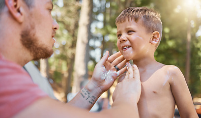 Image showing Father apply sunscreen on child face for protection or safety while camping in a forest or woods for vacation or holiday. Lotion, cream and dad care for kid with skincare product in outdoor adventure