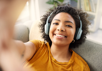 Image showing Music headphones, face and selfie of woman in home living room for live streaming. Portrait, smile and African person listening to radio, audio or podcast for profile picture, happy memory and social
