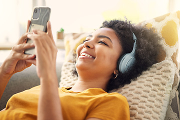 Image showing Relax, couch and woman with a smartphone, headphones and home with happiness, stress relief and streaming music. Smile, female person or girl on a sofa, headset and chilling with a cellphone and song