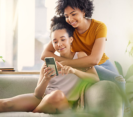 Image showing African lesbian couple, sofa and phone with texting, social network app and relax with meme in living room. Women, together and smartphone for chat, contact or watch internet video on lounge couch