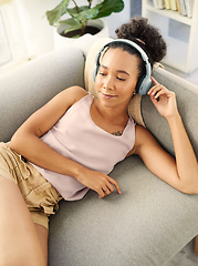 Image showing Relax, music headphones and woman on sofa in home living room for streaming. Hip hop, couch and African person listening to radio, audio or podcast, jazz song and sound for thinking alone in house.