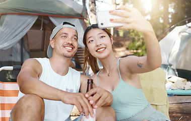Image showing Selfie, love and young couple on a camp in the woods for a summer weekend trip or holiday. Happy, smile and man with beer while his girlfriend taking a picture in forest on outdoor vacation together.