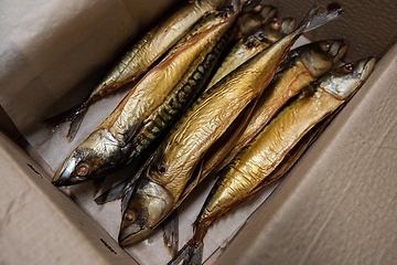 Image showing Smoked fish in craft paper box.