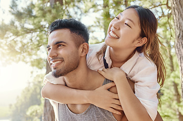 Image showing Hiking, camping or piggyback with a young couple outdoor in nature for romance, dating or exploration. Adventure, smile and love with a man carrying his girlfriend in the forest, woods or wilderness