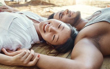 Image showing Hiking, camping and a young couple lying on the ground together outdoor in nature for travel or adventure. Love, smile or freedom with a happy asian woman and her boyfriend bonding in the wilderness