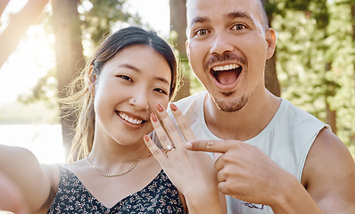 Image showing Couple, engagement and ring in selfie with smile, excited face and pointing for memory in forrest. Young man, happy woman and jewellery for proposal, marriage offer and photography for social network