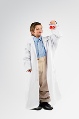 Image showing Science, chemicals and boy child in studio doing a chemistry experiment, project or discovery. Liquid, glass beaker and full body of kid scientist model doing scientific research by white background.