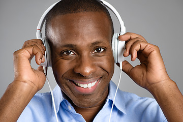 Image showing Music, portrait of a black man with headphones and against studio background happy listening to radio. Podcast or audio, sound playlist or smile and face of African male person streaming media