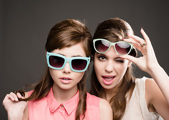 Image showing Fashion, vintage and wink with portrait of women in studio for elegant, pastel and beauty. Sunglasses, confident and cosmetics with female model on dark background for glamour, beehive and style