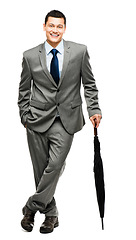 Image showing Portrait, umbrella and insurance with a business man in studio isolated on a white background for cover. Finance, security and winter with a male broker or agent standing indoor for in a suit