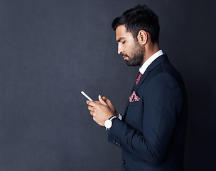 Image showing Phone, typing and business man isolated on a dark gray background for career news, information or social media. Corporate person in suit reading chat on smartphone for networking and job opportunity