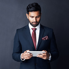 Image showing Business man, tablet and dark background for trading online, planning stock market research and corporate data in studio. Serious trader, indian male person and digital technology for website on app