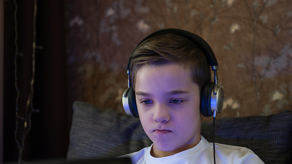 Image showing Kid boy or teen learning at home on laptop for school.