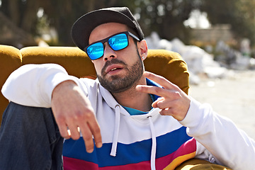 Image showing Trendy fashion, portrait of a man with peace sign and sunglasses outdoors on couch. Freedom or youth, relax or hip hop and male person with emoji hand gesture for urban culture outside on sofa