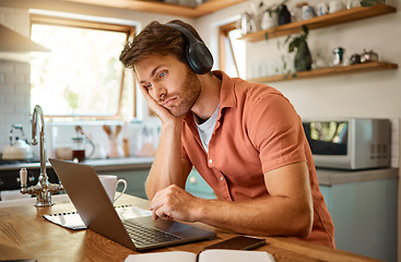 Image showing Laptop, remote work and bored man in kitchen to scroll email, social media or networking for online job. Technology, internet and tired freelancer with boring research in for blog, article or video.