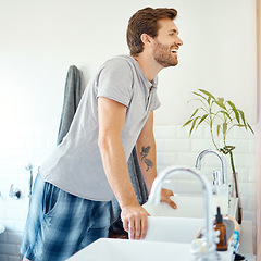 Image showing Man in bathroom, checking teeth in mirror and smile with morning routine, health and wellness in home. Dental care, clean mouth and face with male grooming for fresh breath, hygiene and getting ready