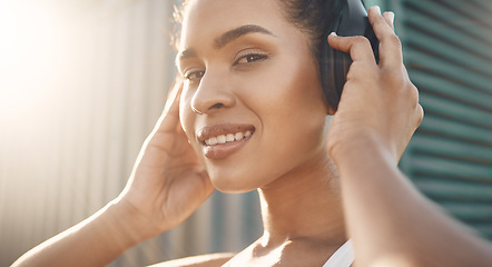 Image showing Face, portrait of a woman and with headphones for motivation for training. Lens flare and happy smile, workout or exercise of female athlete listening to fitness music for health, sport or wellness