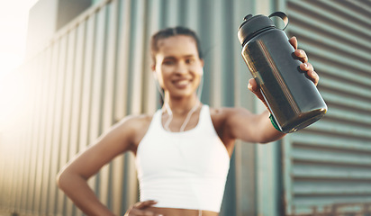 Image showing Earphones, runner or happy woman with bottle in city to hydrate or relax on exercise or water break. Tired blur, thirsty or portrait of girl with liquid for hydration in fitness training or workout