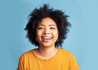 Image showing Happy, woman and portrait with natural beauty, confidence or smile with makeup on studio blue background. Face, happiness and person with African hair, afro or cosmetics to care for hairstyle