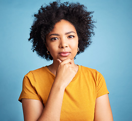 Image showing Portrait, serious and woman with a decision, focus and girl against a blue studio background. Face, female person or model with problem solving, solution or fantasy with future, assertive or question