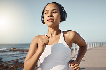 Image showing Fitness, woman run at beach and with headphones listening to music for training. Exercise or marathon, lens flare or sportswear and female athlete running along the promenade listen to radio