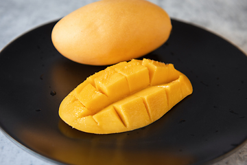 Image showing Fresh yellow mango fruit in a black plate