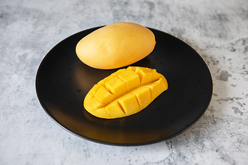 Image showing Fresh yellow mango fruit in a black plate