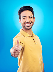 Image showing Thumbs up, success portrait and man on blue background for thank you, winning or yes, like emoji and social media subscribe. Winner, person or asian model in okay, support or good job sign in studio