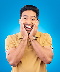 Image showing Happy, excited man and surprise portrait in studio with Asian model with teeth and joy. Blue background, male person and casual fashion with handsome and friendly guy with modern style and wow face